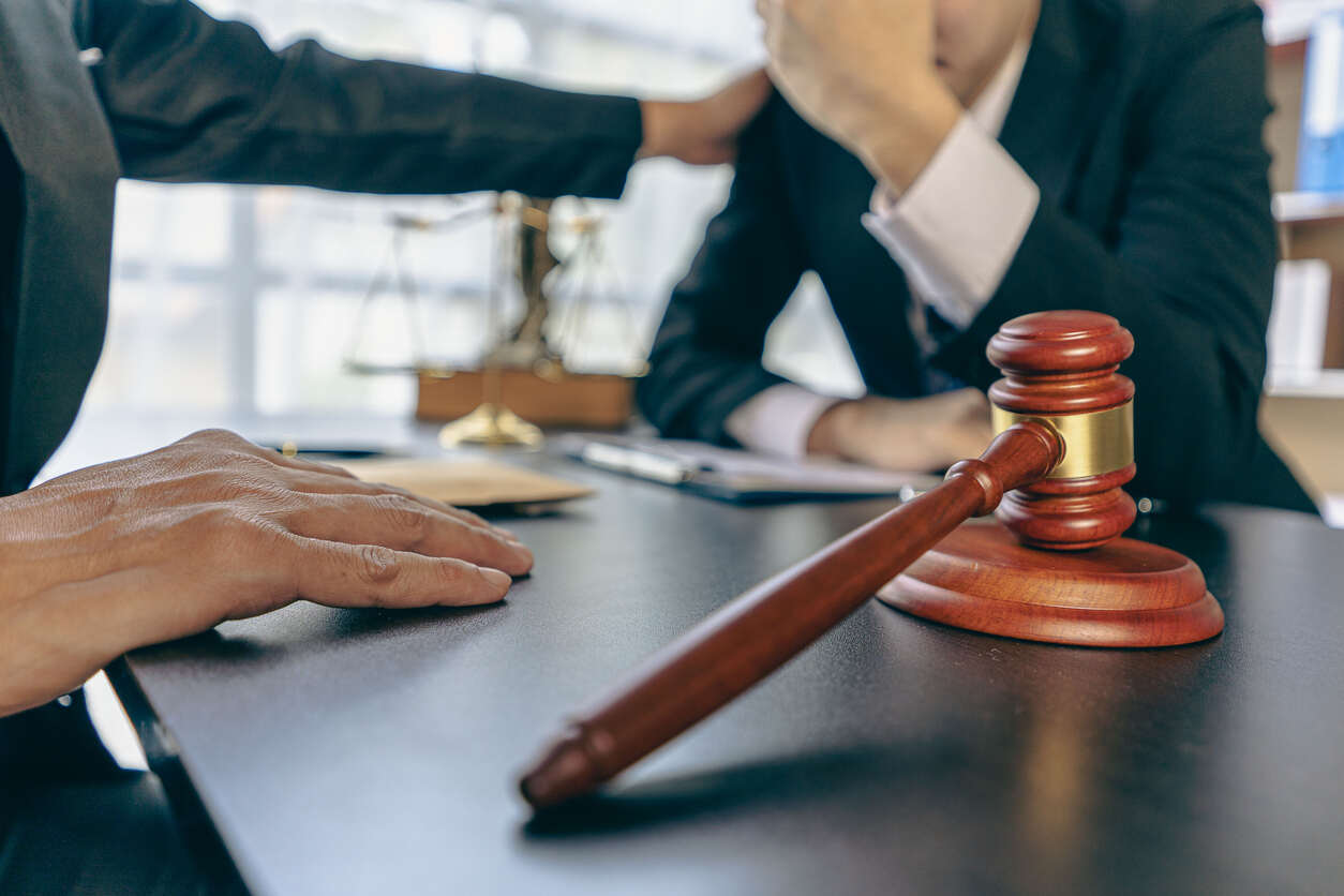 Lawyer and client in a consultation setting with legal symbols, highlighting the expertise of employment law attorneys in Manhattan Beach, California.